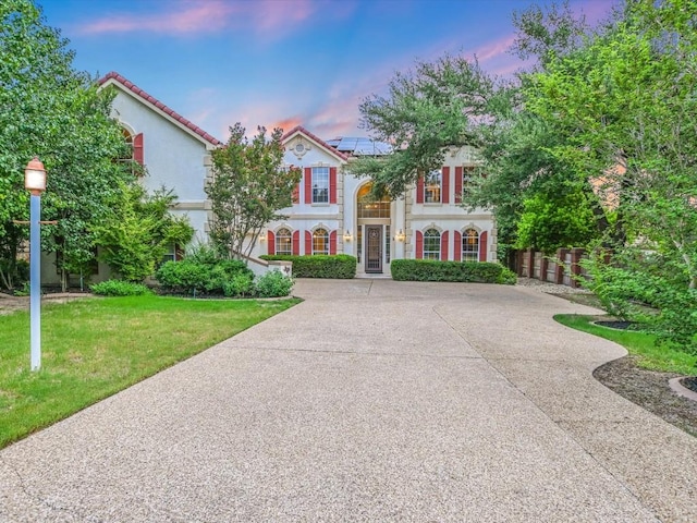 6 Wingreen Loop, The Hills, TX 78738 - mediterranean / spanish-style home with solar panels, stucco siding, and driveway