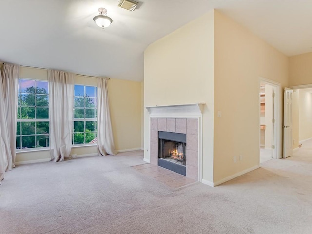 unfurnished living room featuring visible vents, baseboards, vaulted ceiling, carpet flooring, and a fireplace