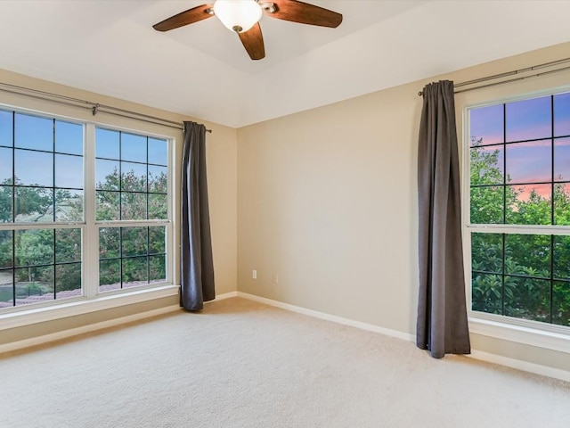 unfurnished room featuring ceiling fan, a tray ceiling, baseboards, and carpet floors