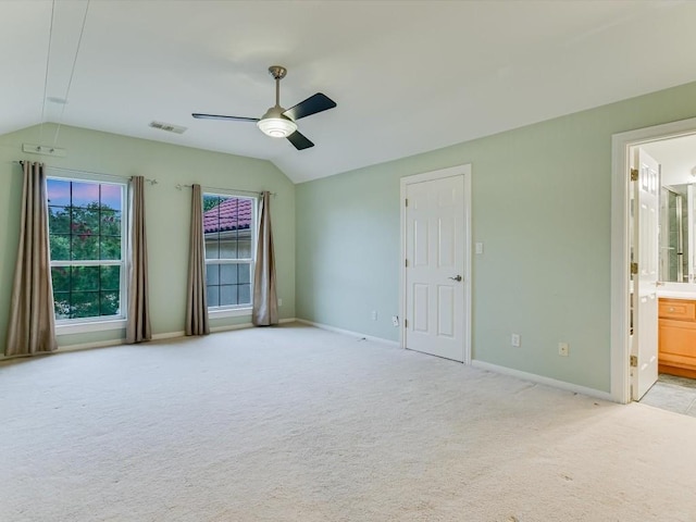 unfurnished bedroom with visible vents, baseboards, light colored carpet, ceiling fan, and vaulted ceiling