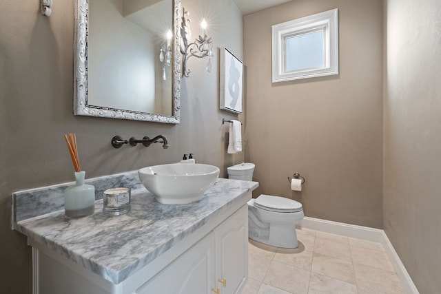 bathroom featuring vanity, tile patterned flooring, toilet, and baseboards