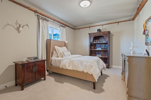 bedroom with light carpet and baseboards