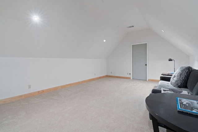 interior space featuring lofted ceiling, light colored carpet, visible vents, and baseboards