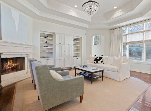 living room featuring a tray ceiling, a healthy amount of sunlight, and a fireplace