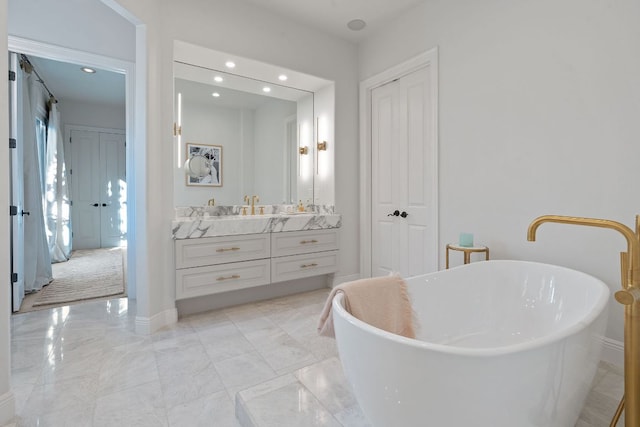 bathroom featuring baseboards, marble finish floor, a freestanding bath, vanity, and recessed lighting