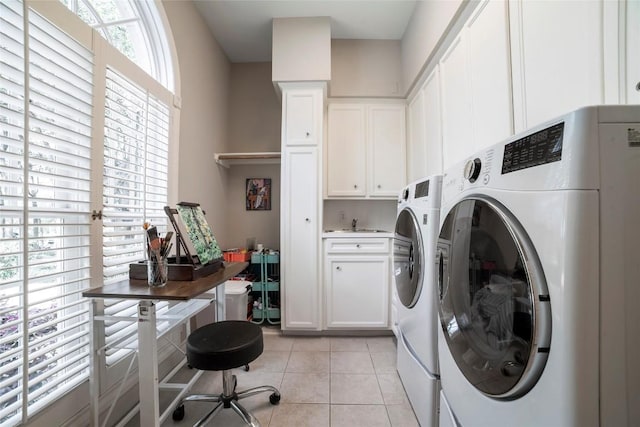 laundry room with light tile patterned floors, cabinet space, and washer and dryer