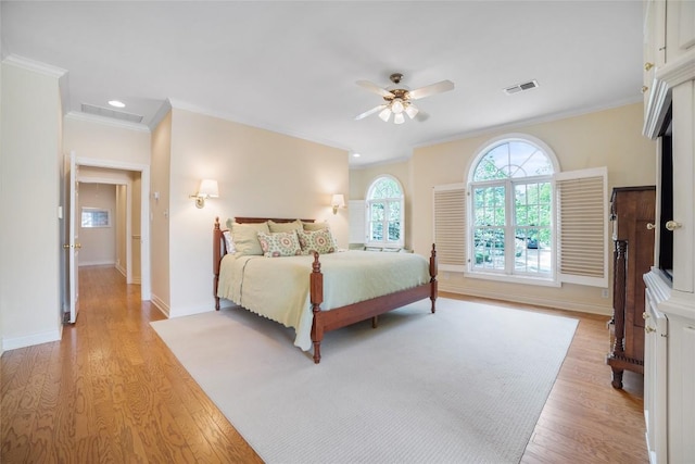 bedroom with a ceiling fan, baseboards, visible vents, light wood-style floors, and ornamental molding