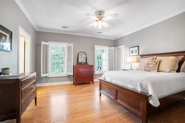 bedroom featuring light wood-type flooring, visible vents, crown molding, and baseboards