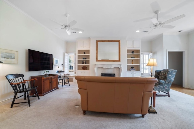 living area with a fireplace, light colored carpet, a wealth of natural light, and crown molding