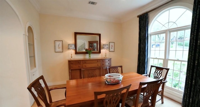 dining room with arched walkways, visible vents, and baseboards