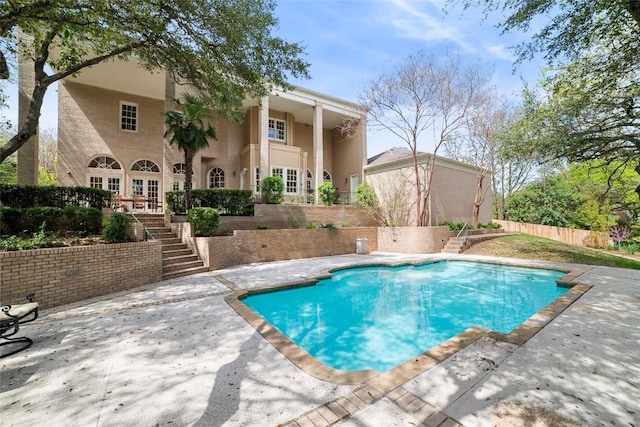 view of swimming pool with a fenced in pool, french doors, stairway, a patio area, and fence