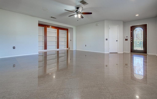 interior space featuring ceiling fan, granite finish floor, visible vents, and baseboards