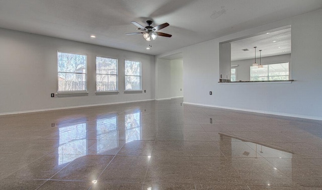 spare room featuring granite finish floor, baseboards, and recessed lighting