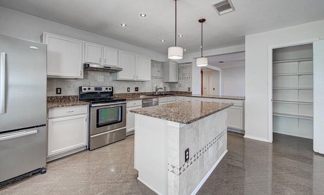 kitchen with under cabinet range hood, granite finish floor, visible vents, and stainless steel appliances