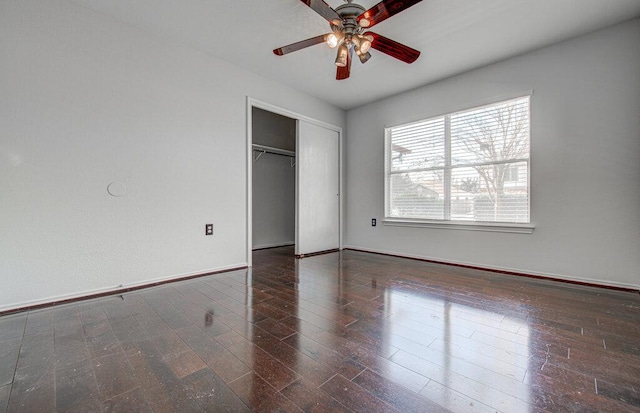 unfurnished bedroom with a closet, wood finished floors, a ceiling fan, and baseboards