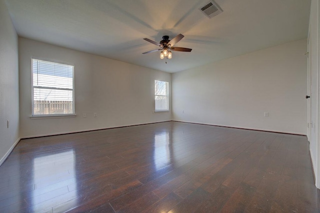 unfurnished room with visible vents, ceiling fan, baseboards, and wood finished floors