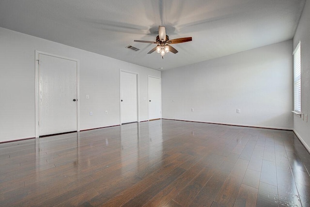 spare room with baseboards, ceiling fan, visible vents, and wood finished floors