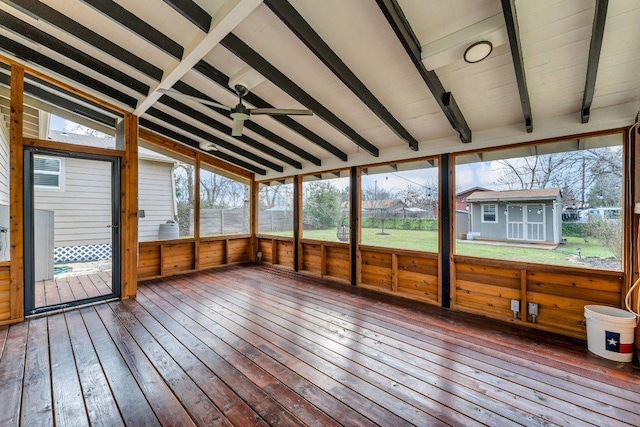 unfurnished sunroom featuring vaulted ceiling with beams and ceiling fan