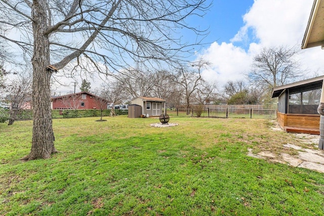 view of yard featuring an outbuilding, a storage unit, and a fenced backyard