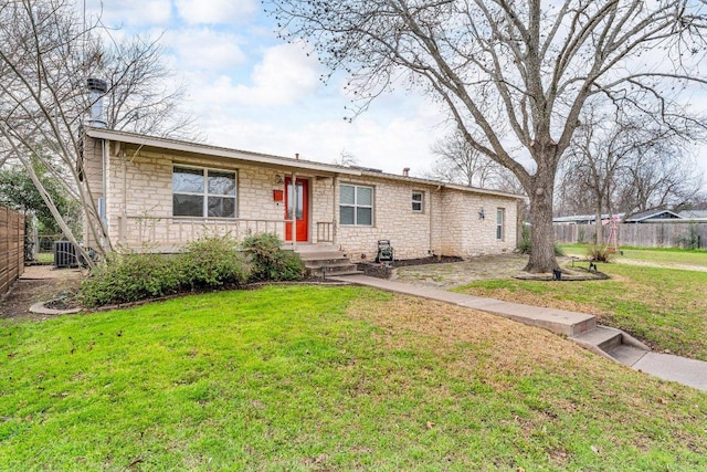 single story home with central air condition unit, stone siding, fence, and a front yard