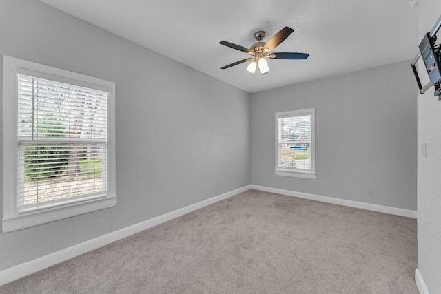 spare room featuring a ceiling fan, baseboards, and carpet flooring