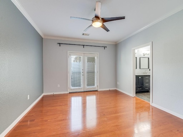 unfurnished room with crown molding, visible vents, wood finished floors, and french doors