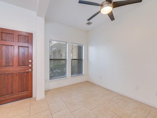 unfurnished room with a ceiling fan, visible vents, baseboards, and light tile patterned floors