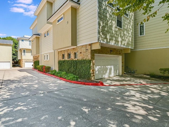 view of building exterior with an attached garage and a residential view