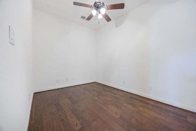 empty room with dark wood-style floors, ceiling fan, visible vents, and baseboards