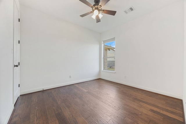 unfurnished room with dark wood-style floors, baseboards, visible vents, and ceiling fan