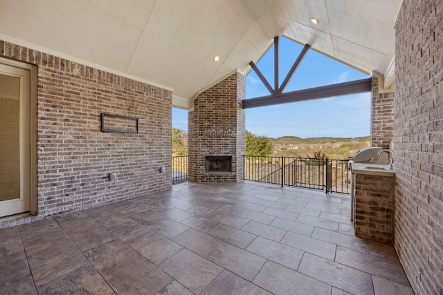 view of patio / terrace featuring an outdoor brick fireplace and area for grilling