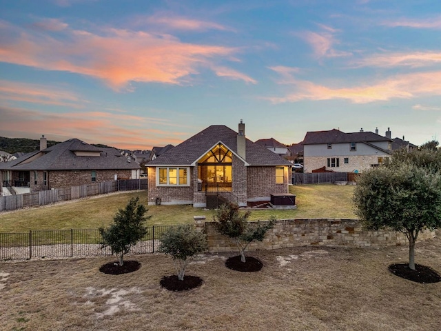 view of front of home featuring a fenced backyard, a chimney, and a yard