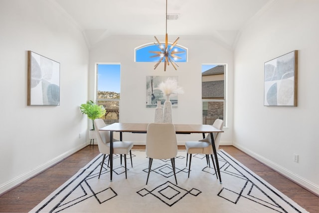 dining room featuring a chandelier, lofted ceiling, and wood finished floors