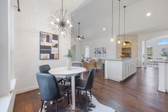 dining room with baseboards, arched walkways, dark wood-style flooring, high vaulted ceiling, and recessed lighting