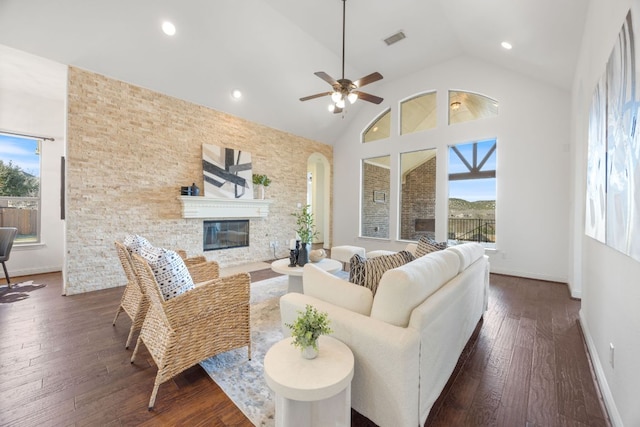 living room with high vaulted ceiling, visible vents, dark wood-type flooring, and a glass covered fireplace