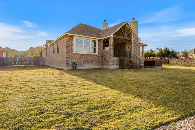 view of front of house with brick siding, fence, a chimney, and a front lawn