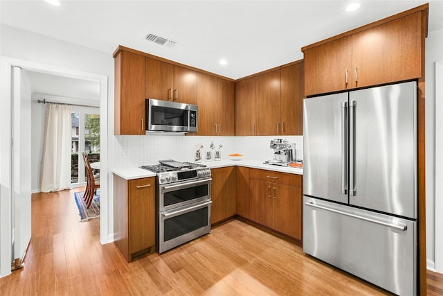 kitchen featuring light wood-style floors, visible vents, appliances with stainless steel finishes, and light countertops