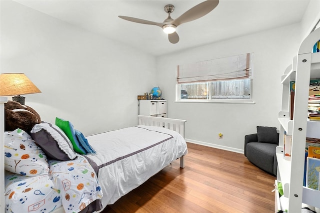 bedroom featuring ceiling fan, wood finished floors, and baseboards