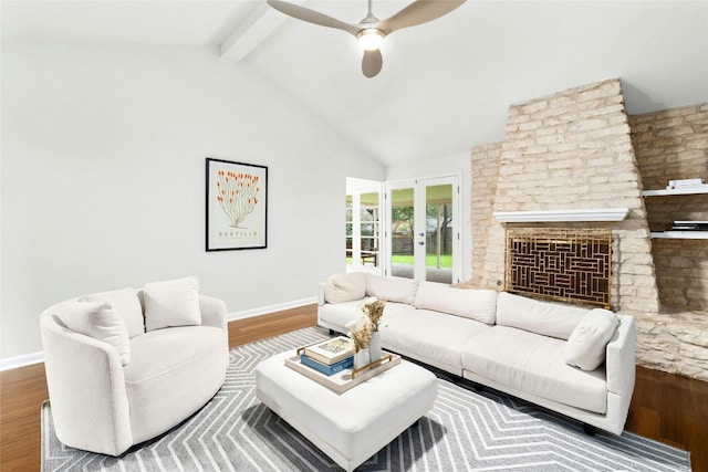 living room featuring beamed ceiling, a fireplace, wood finished floors, and baseboards