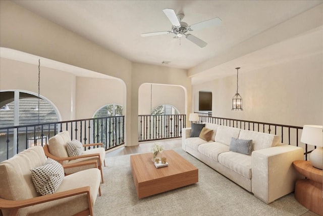 living room featuring lofted ceiling and ceiling fan with notable chandelier