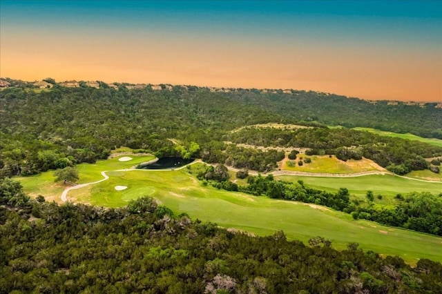 aerial view at dusk with a view of trees and golf course view