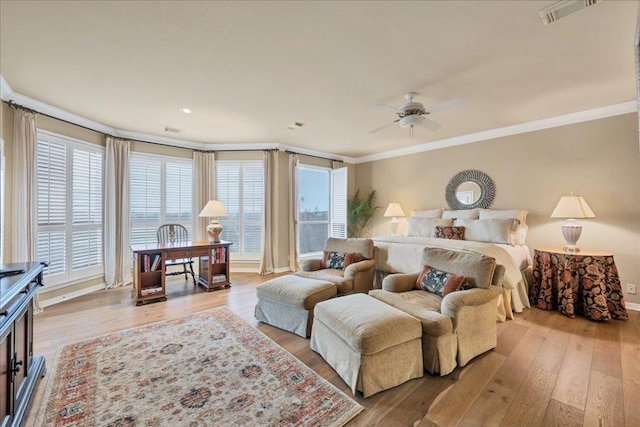 bedroom with light wood-style flooring, visible vents, and crown molding