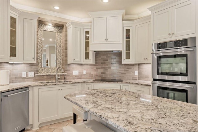 kitchen with decorative backsplash, stainless steel appliances, a sink, and ornamental molding