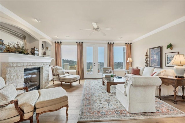 living room with light wood-type flooring, a wealth of natural light, and crown molding