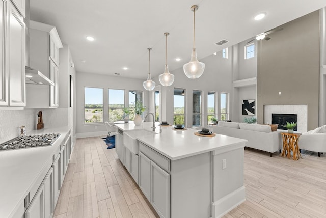 kitchen featuring stainless steel gas cooktop, tasteful backsplash, light countertops, visible vents, and light wood-style floors