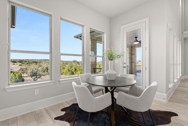 dining space with light wood-type flooring and baseboards