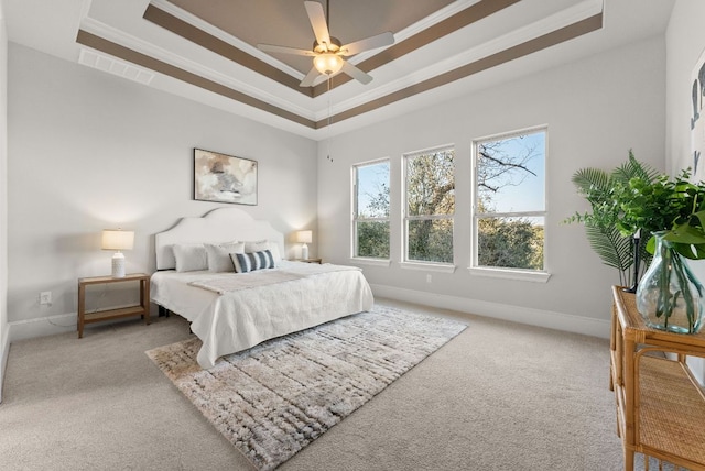 bedroom with light carpet, a tray ceiling, visible vents, and baseboards