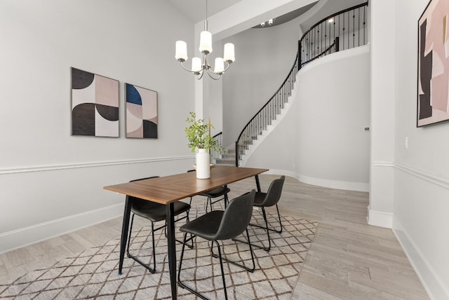 dining room with baseboards, stairway, wood finished floors, and an inviting chandelier