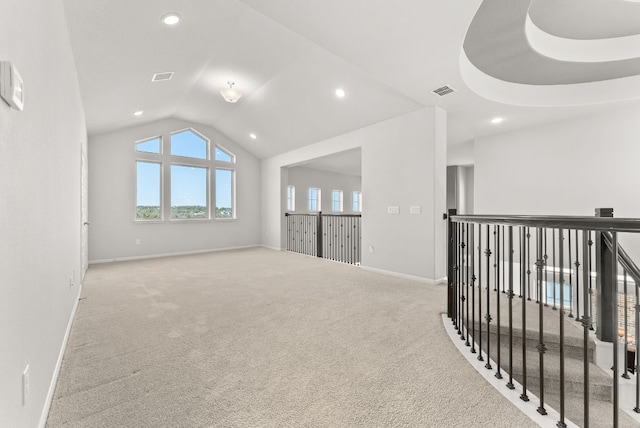 spare room with carpet floors, recessed lighting, visible vents, vaulted ceiling, and baseboards