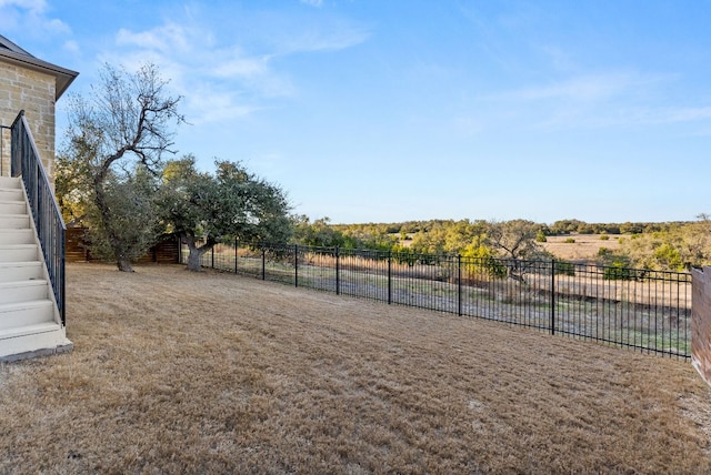 view of yard featuring stairs and fence